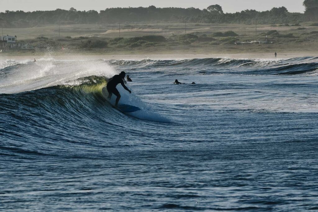 Men surfing a wave in the atlantic ocean in cabo polonio rocha